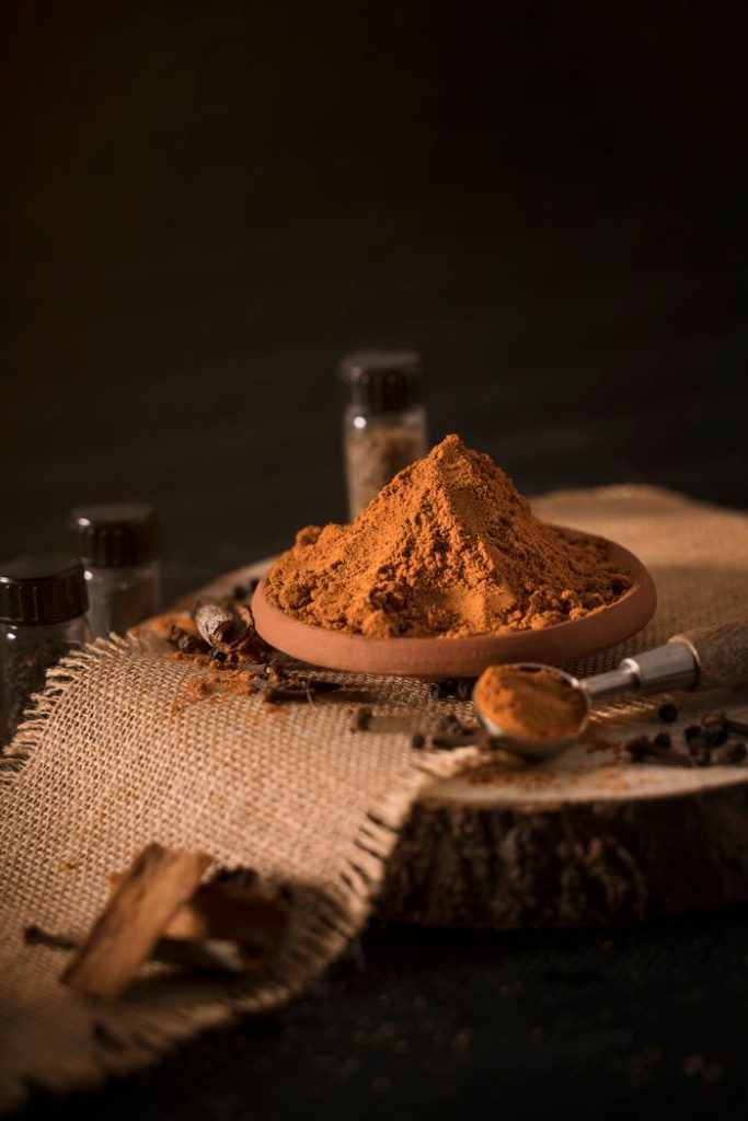 Aesthetic arrangement of spices with cinnamon and cloves in a rustic setting.